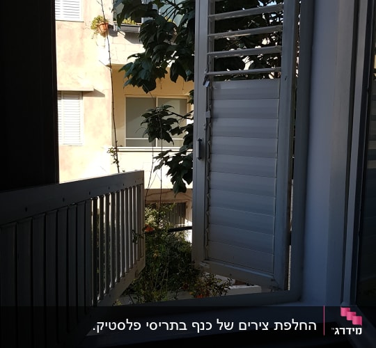 תריסים פתוחים בחלון עם נוף חיצוני
